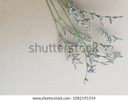 Cute little flower is placed on a brown paper texture background, craft paper