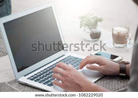 Happy woman using laptop at cafe. Young beautiful girl sitting in a coffee shop and working on computer Royalty-Free Stock Photo #1082229020