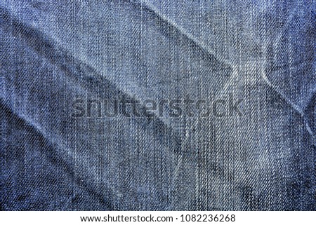 Denim texture blue frayed fabric with pleats background 