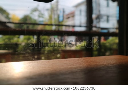 A picture of a wooden table next to a glass window.