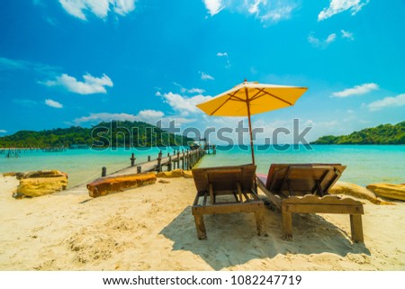 Umbrella and chair on the Beautiful tropical beach and sea with coconut palm tree in paradise island for travel and vacation
