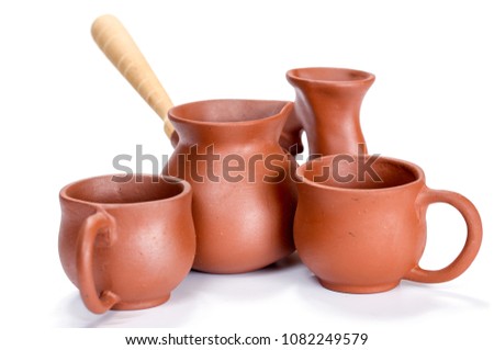 Clay dishes. Cups and a Turk on a white background