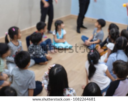 Group of children sitting on the floor in the classroom in blurred picture, blur concept. 