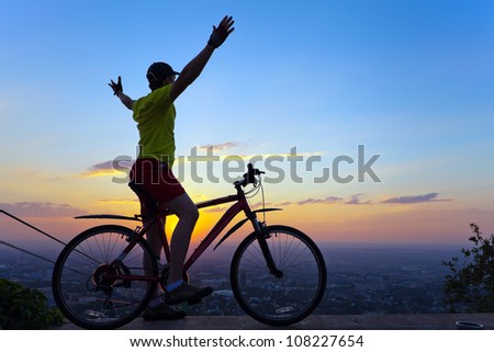 Picture of a cyclist with a panorama of the city at sunset, Almaty.