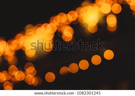 Abstract orange or golden bokeh background with free space for text. Bokeh urban blurring colours concept. Night life of a big city. Defocused light with black background. Lounge bar. 