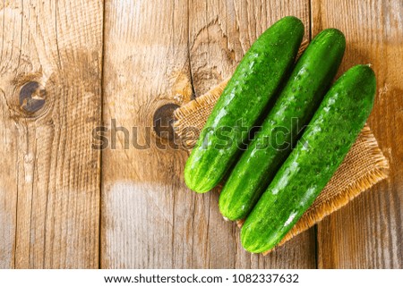 Fresh cucumbers with a leaf on an old wooden table