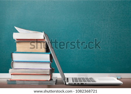 Stack of books with laptop
