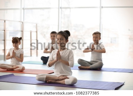 Little children practicing yoga in gym Royalty-Free Stock Photo #1082377385