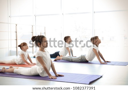 Little children practicing yoga in gym Royalty-Free Stock Photo #1082377391