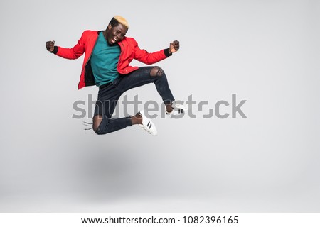Portrait of a cheerful afro american man jumping isolated on a white background