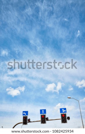 Traffic lights with countdown timers, red color displayed against the blue sky, space for text.