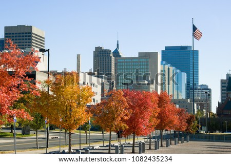 Oklahoma city skyline in fall foliage with flying American flag