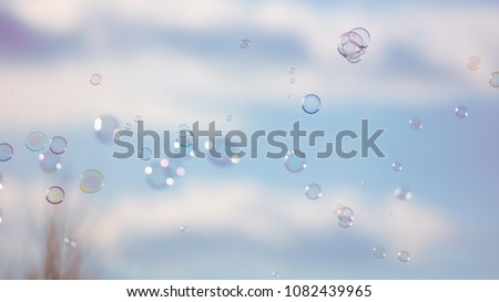Soap bubbles in flight against the sky