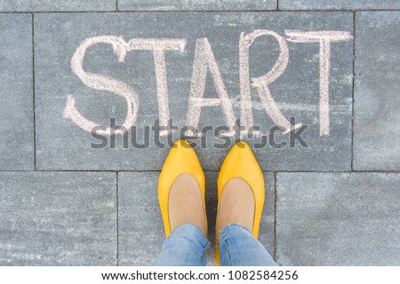 Word start on the asphalt and feet woman Royalty-Free Stock Photo #1082584256