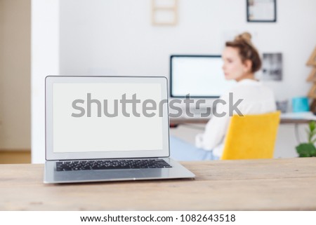 People, modern lifestyle, technology concept. Digital generic laptop computer with blank screen for your promotional text in large creative office