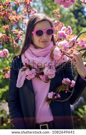 portrait of a girl in pink sunglasses standing in pink cherry blossoms sakura