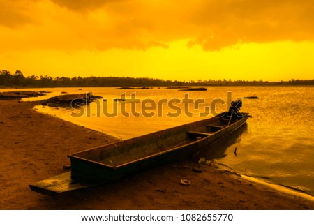 The sun sets over Lake, Rainy season fishing boat on gold sky