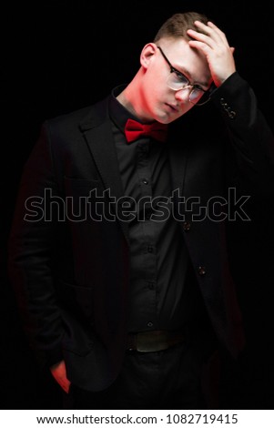 Portrait of confident handsome elegant responsible businessman thinking holding hand on his head on black background