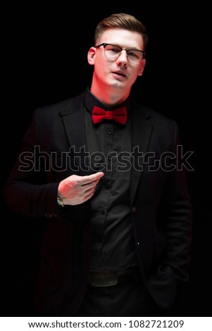 Portrait of confident handsome elegant responsible businessman with hand on his jacket on black background