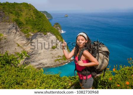 young happy and beautiful sporty Asian Korean or Chinese woman carrying big backpack trekking on beautiful beach cliff landscape in backpacker holidays trip and Summer excursion concept