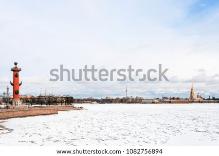 view of frozen Neva river and Spit of Vasilyevsky Island with Rostral Column and Peter and Paul Fortress in Saint Petersburg city in march