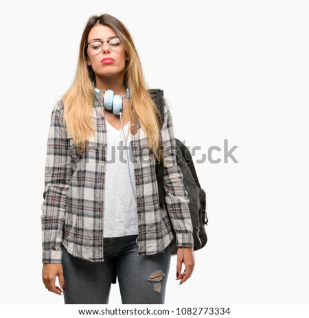 Young student woman with headphones and backpack with sleepy expression, being overworked and tired