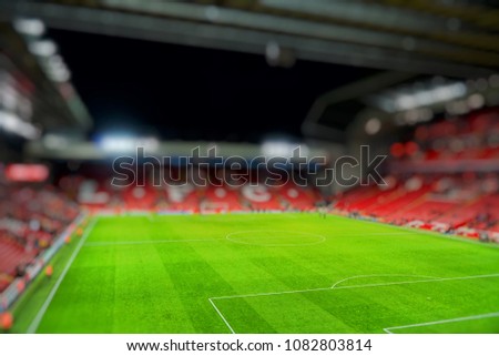 Blurred background of football stadium and soccer fans in match day on beautiful green field with sport light at the stadium.Sports,Athlete,People Concept.Mercy side,Anfield,Liverpool.  Royalty-Free Stock Photo #1082803814