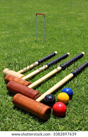 Croquet mallets and balls lying on the lawn. Royalty-Free Stock Photo #1082897639