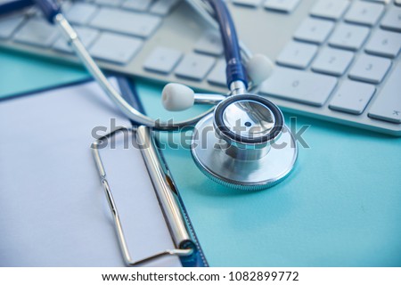 Stethoscope with clipboard and Laptop on desk,Doctor working in hospital writing a prescription. Healthcare and medical concept, test results in background, selective focus Royalty-Free Stock Photo #1082899772