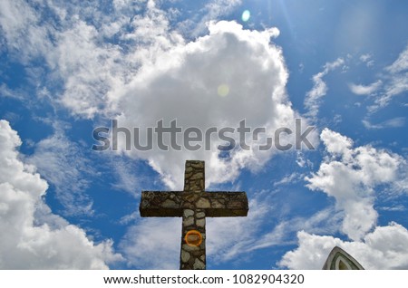Stone Cross, silhouette,  Low Angle against blue sky with white clouds on bright day, Cemetery in Salinto, Columbia, South America