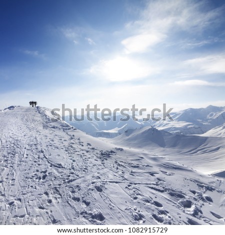 Top station of ropeway and snowy road with footprint on ski resort at sun evening. Caucasus Mountains, Georgia, region Gudauri at winter.