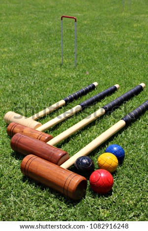 Croquet mallets and balls lying on the lawn. Royalty-Free Stock Photo #1082916248