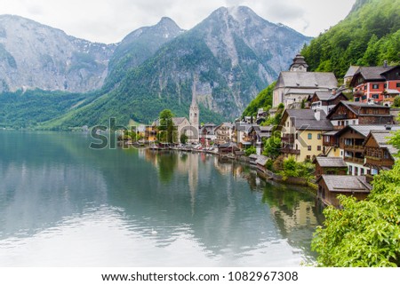 Scenic picture-postcard view of famous Hallstatt mountain village in the Austrian Alps with passenger ship in beautiful morning light at sunrise on a sunny day in summer, Salzkammergut region, Austria