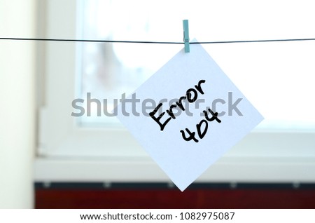 Error 404. Note is written on a white sticker that hangs with a clothespin on a rope on a background of window glass