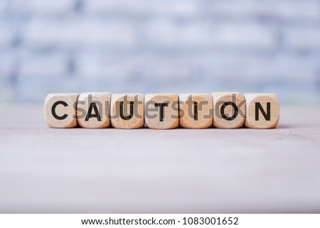 CAUTION word written on wood block