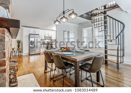 Modern Kitchen Table with Spiral Staircase Royalty-Free Stock Photo #1083014489