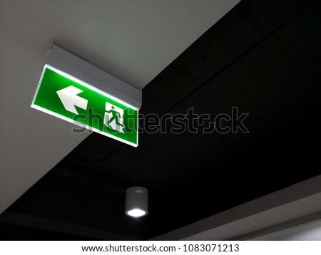 Emergency fire exit sign show the way to escape. Royalty-Free Stock Photo #1083071213