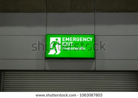 Big green sign and symbol emergency exit way on the wall over the door