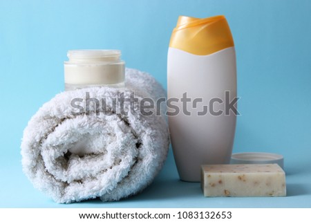 Shower accessories on a colored background. Towel, soap, cream, shower gel, shampoo. means for body care.
 