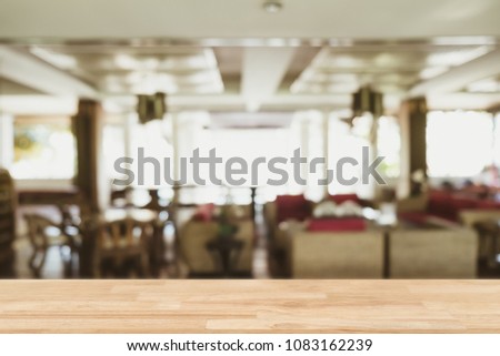 Empty wooden table blurred of restaurant cafe background and reception room, can be used for display or montage your products
