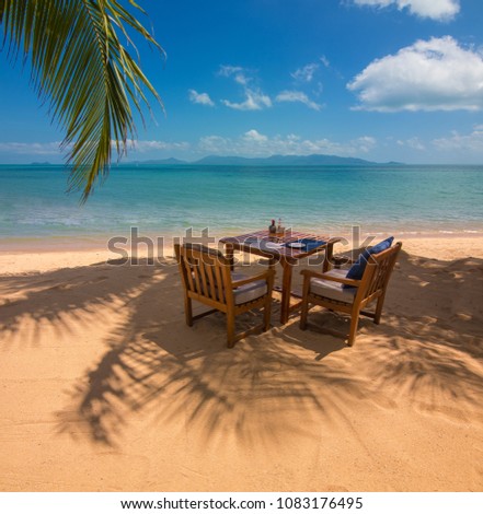 Landscape Sunny day, blue sky and beach, palms and tables with armchairs on the sand