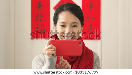 Woman taking family photo with cellphone during lunar new year period 