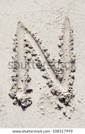 The letter N of the alphabet writing on the sand beach