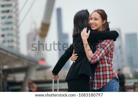 Joyful mother and daughter hug together after mother back form travel