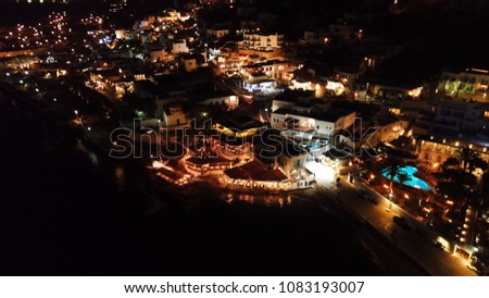 Aerial night shot of Mykonos island chora old port at night with dazzling lights, Cyclades, Greece