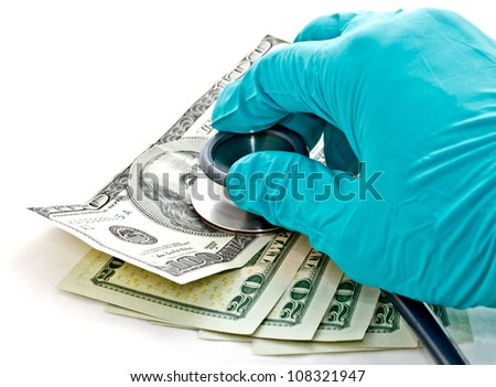 medical treatment and cost concept: doctor's hand hold stethoscope placing on US dollar banknotes