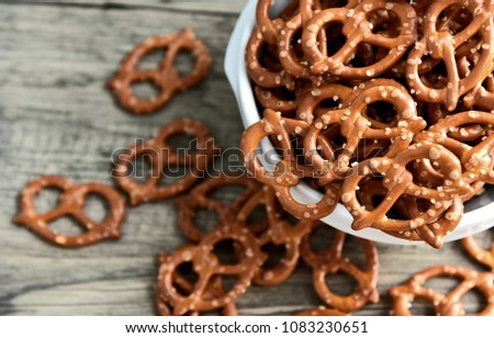 Hard Pretzels or Salted pretzels snack for party in white bowl on wooden floor.  Royalty-Free Stock Photo #1083230651