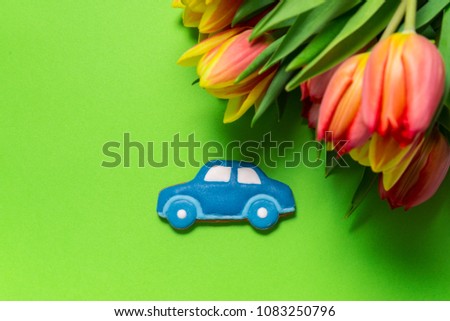 Gingerbread car with tulips on green background