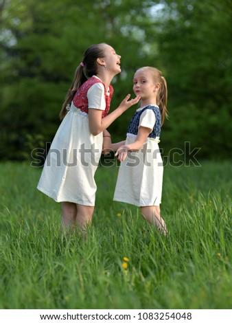 girls having fun outdoors. two sisters in park.