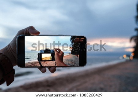 taking a photo of the beach by the camera shown in smartphone frame